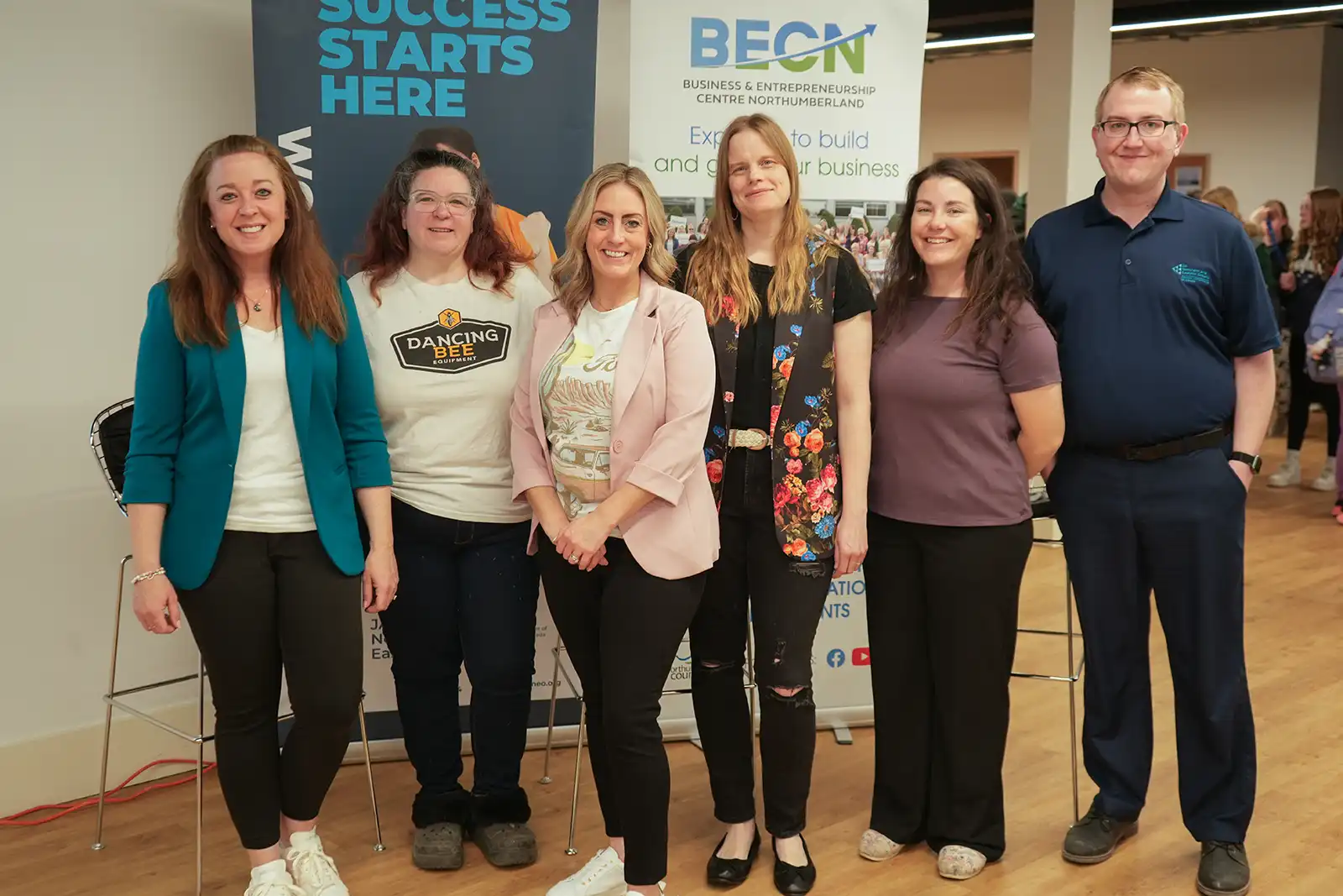 Group of staff standing in front of banners. 